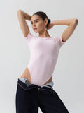 The bodysuit in the image is a crew-neck, short-sleeve style in a soft pink shade.